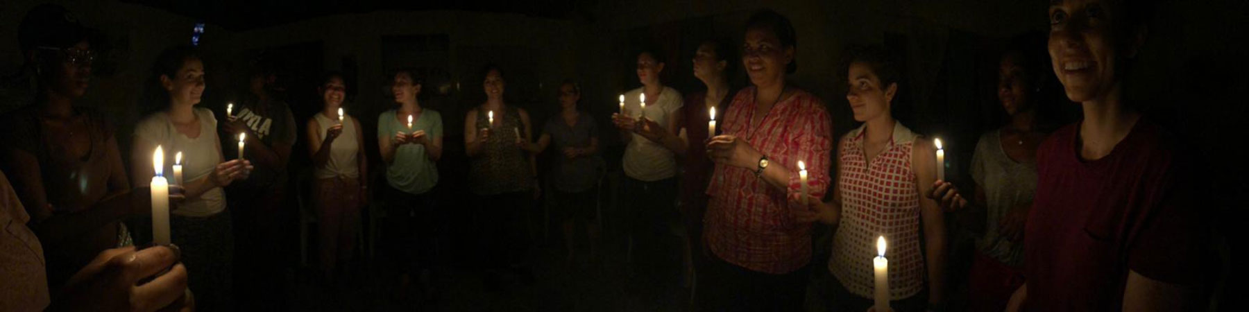 Loyola Chicago students holding candles for group prayer.