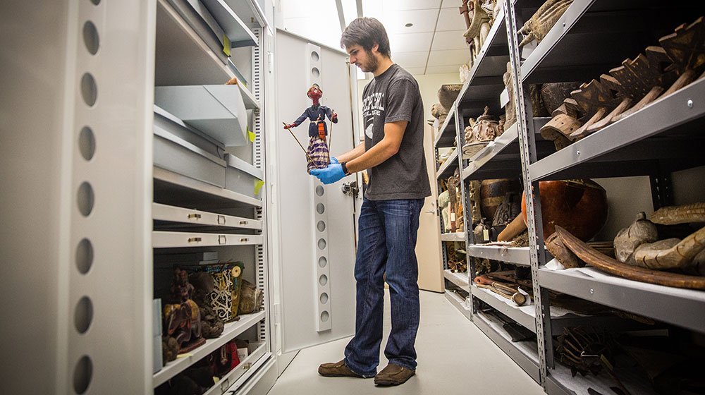 Christian Franck, a student in the Department of Anthropology’s museum studies internship course, holds a puppet that will be in LUMA’s upcoming exhibition on Indonesian puppetry. (Photo: Natalie Battaglia)