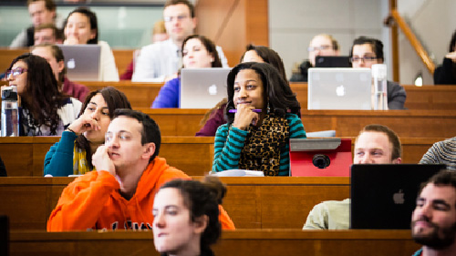 A group of students listen to an unseen lecturer.