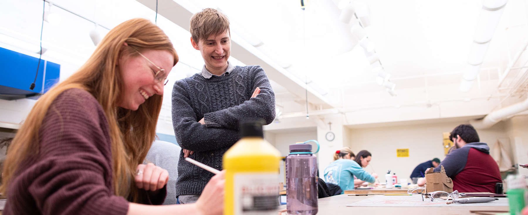 Fine Arts lecturer Betsy Odom stands with a student in their classroom.