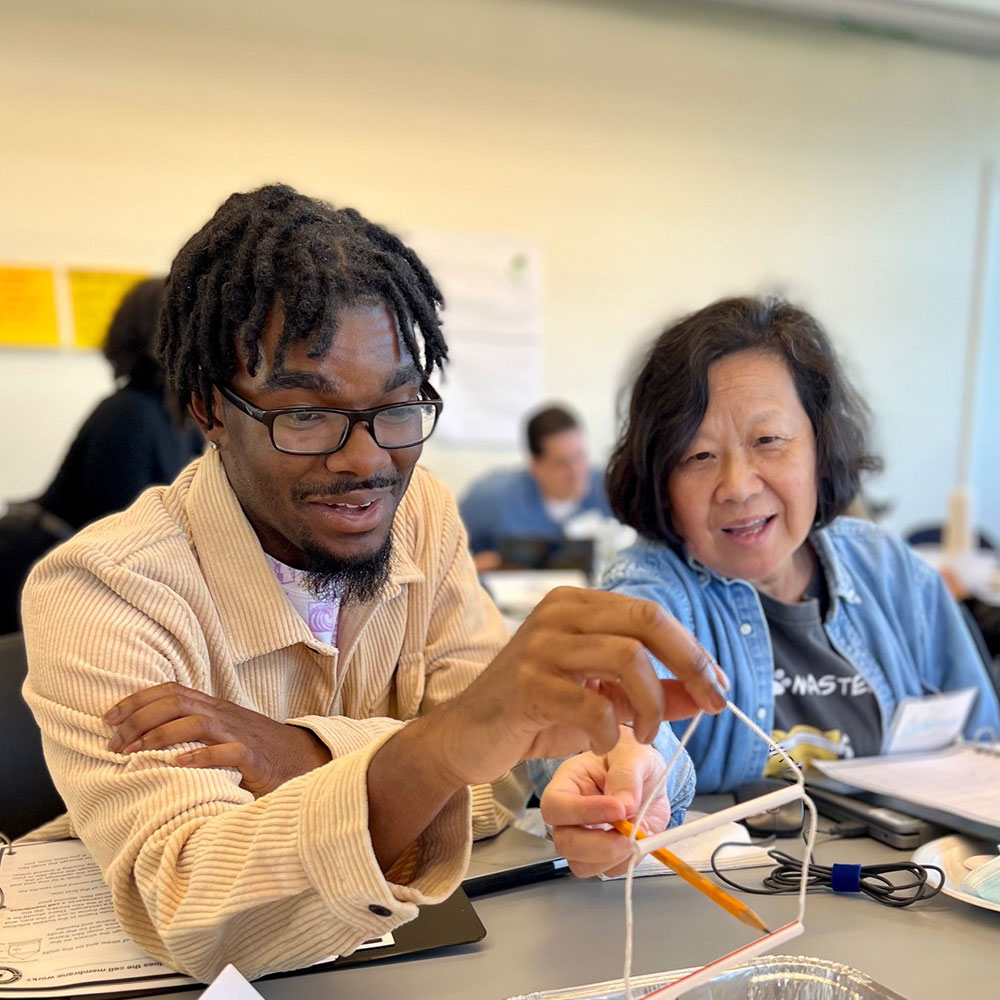 An African-American man and Asian woman work together on a science experiment in a classroom through Loyola's Center for Science and Math Education.
