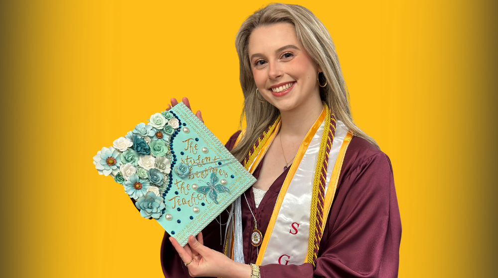 Loyola SOE graduate Alexandra Brist holds up decorated cap