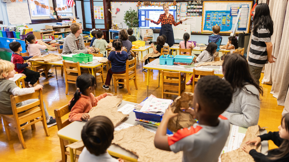 Swift student interns sitting in class with young students