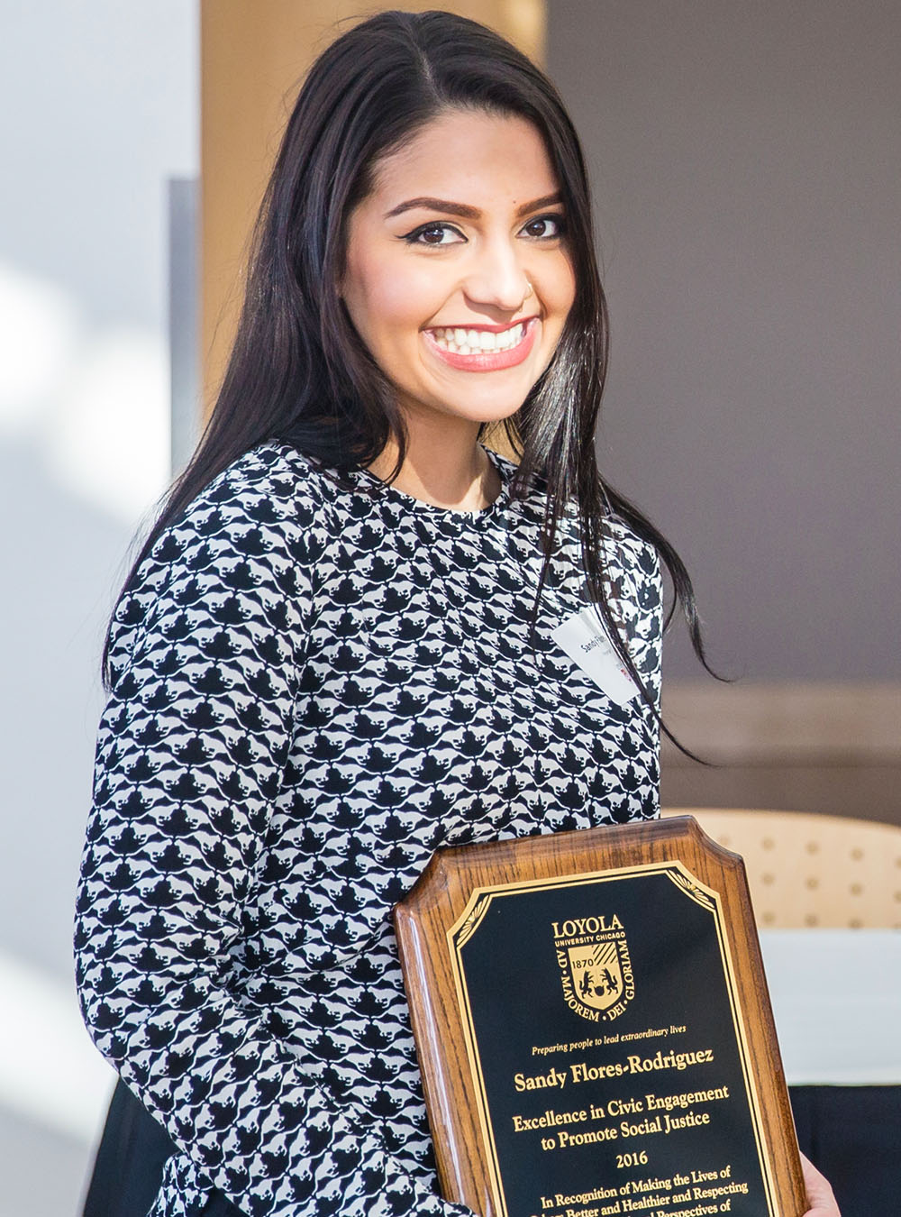 A Loyola graduate student presents their award for their research