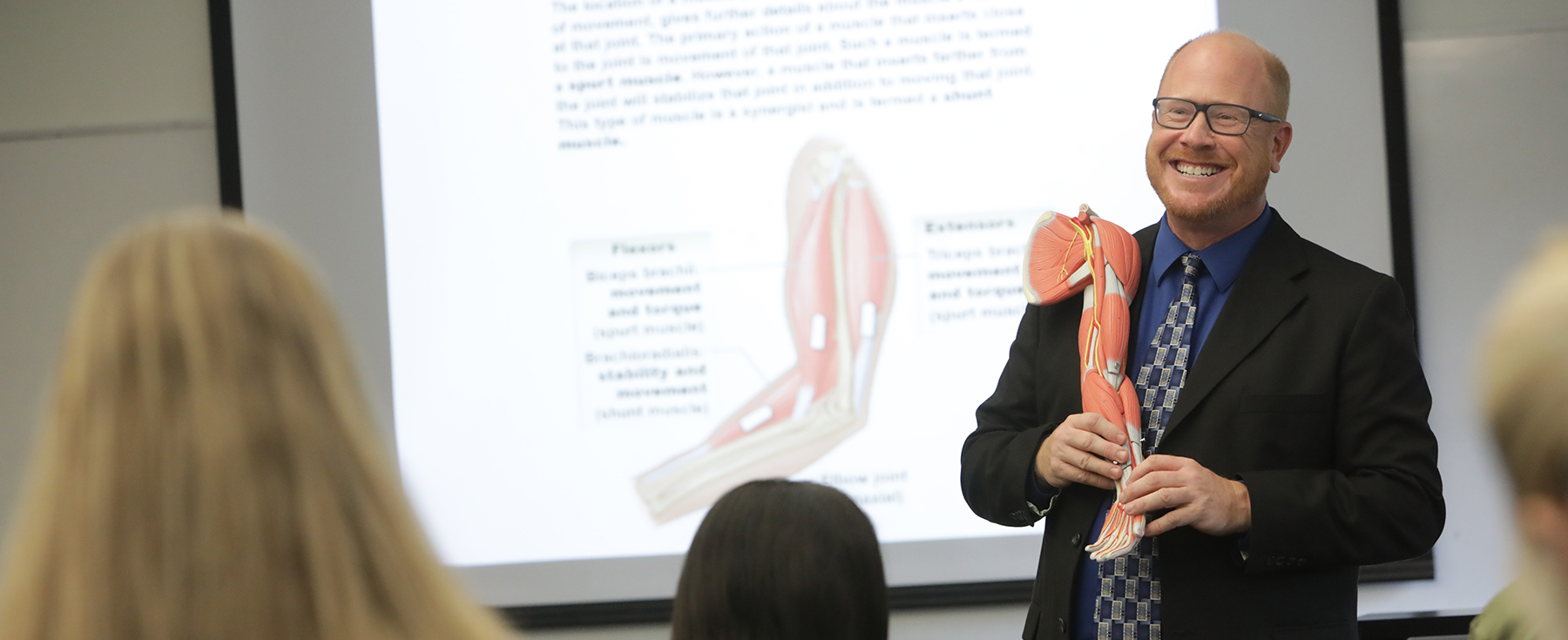 Matt Bruder holds model arm in front of class