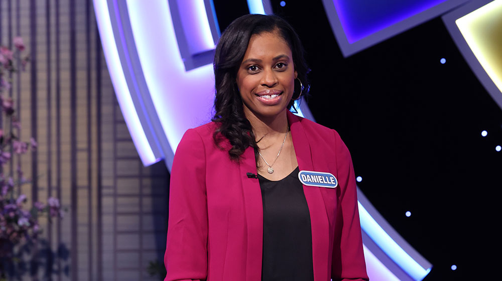 Danielle Booker standing behind the wheel on the Wheel of Fortune set