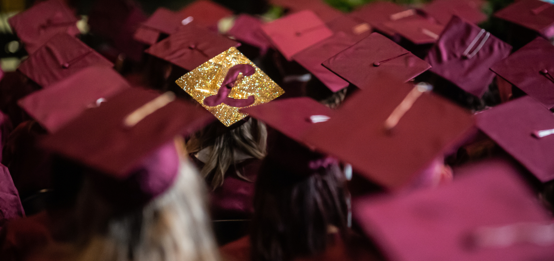 Loyola SCPS graduates with their maroon cap and gown