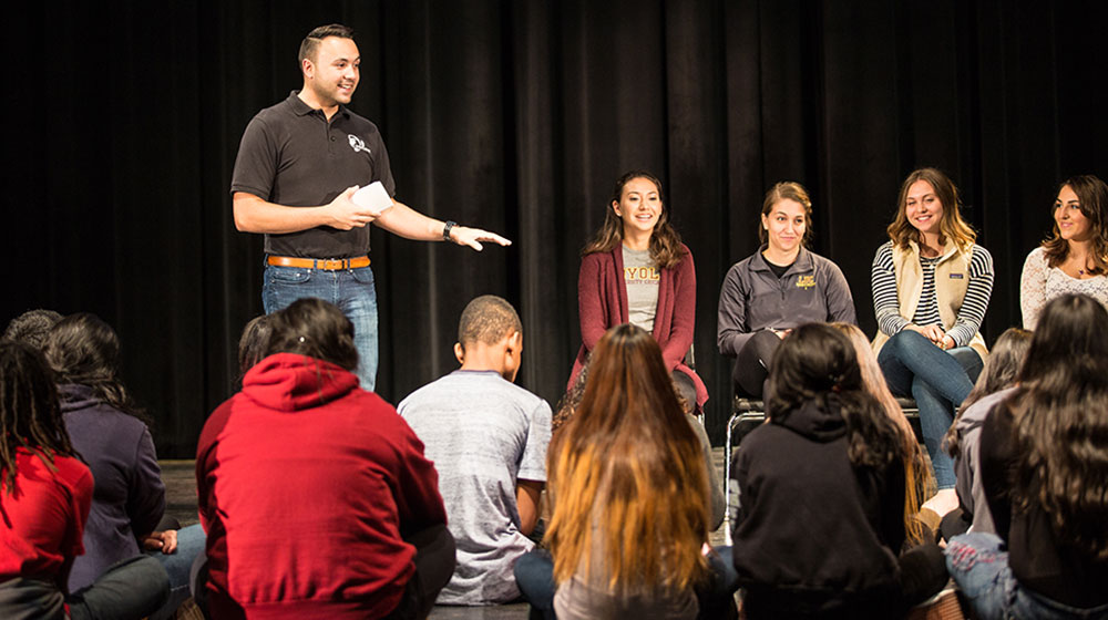 School of Communication graduate Everett Gutierrez and four current Loyola students speak at North-Grand High School recently. Gutierrez is the founder of Legacy Leaders International, which helps mobilize and motivate people to become leaders for the common good. (Photo: Natalie Battaglia)