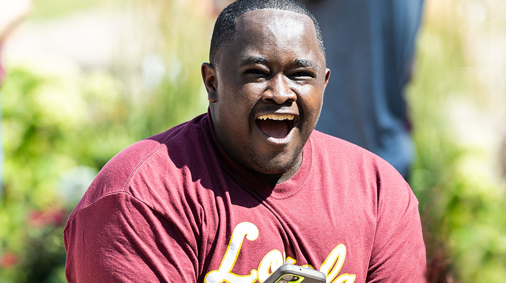 An expressive, smiling, new student celebrates the new student convocation at Loyola University Chicago